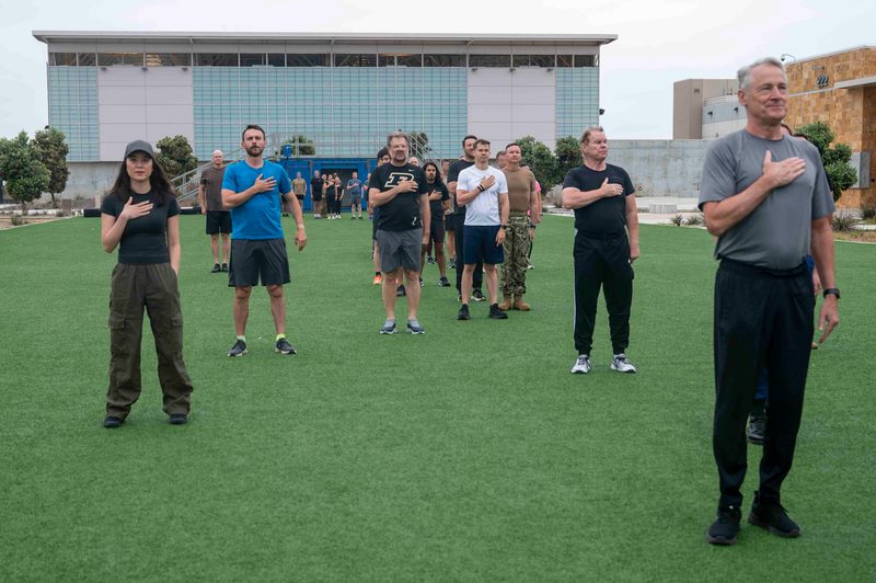 Saluting the flag during the national anthem singing at naval base